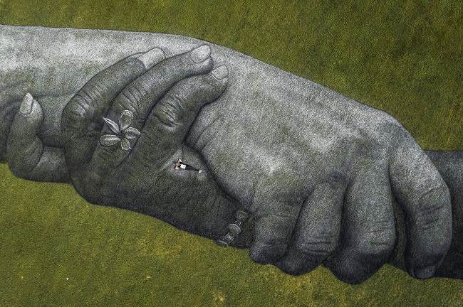 Фреску с гигантским рукопожатием на траве в  археологическом парке Турина Порт-Палатин. Автор художник Гийом Легро, более известный как Сайпе (Saype). Проект Beyond Walls,  #TheNewHumanity